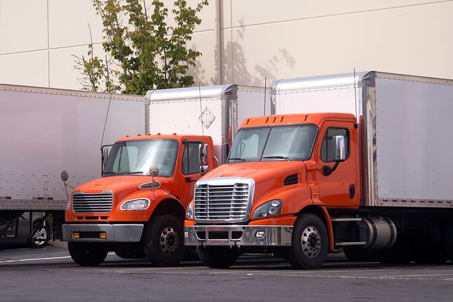 a large orange truck parked on the side of a road